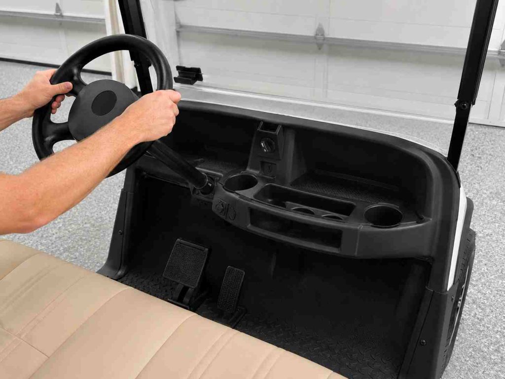 Close-up photorealistic shot of an EZGO RXV electric cart's front dashboard and steering wheel in a clean garage setting